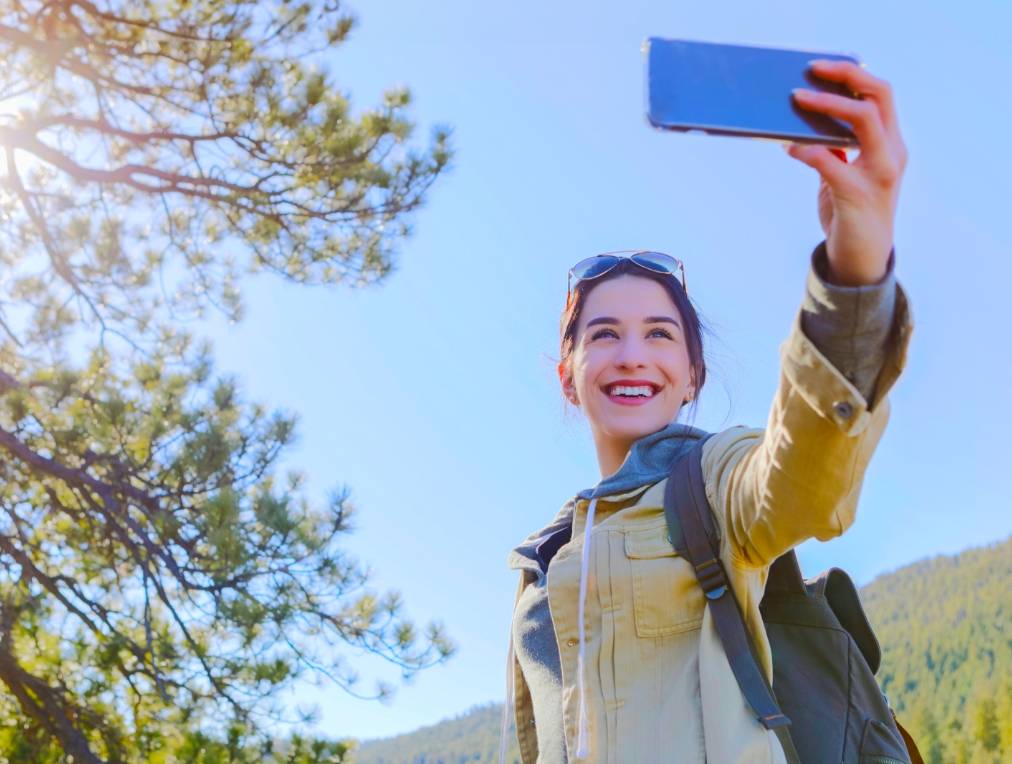 Lady taking a selfie with her phone outdoors