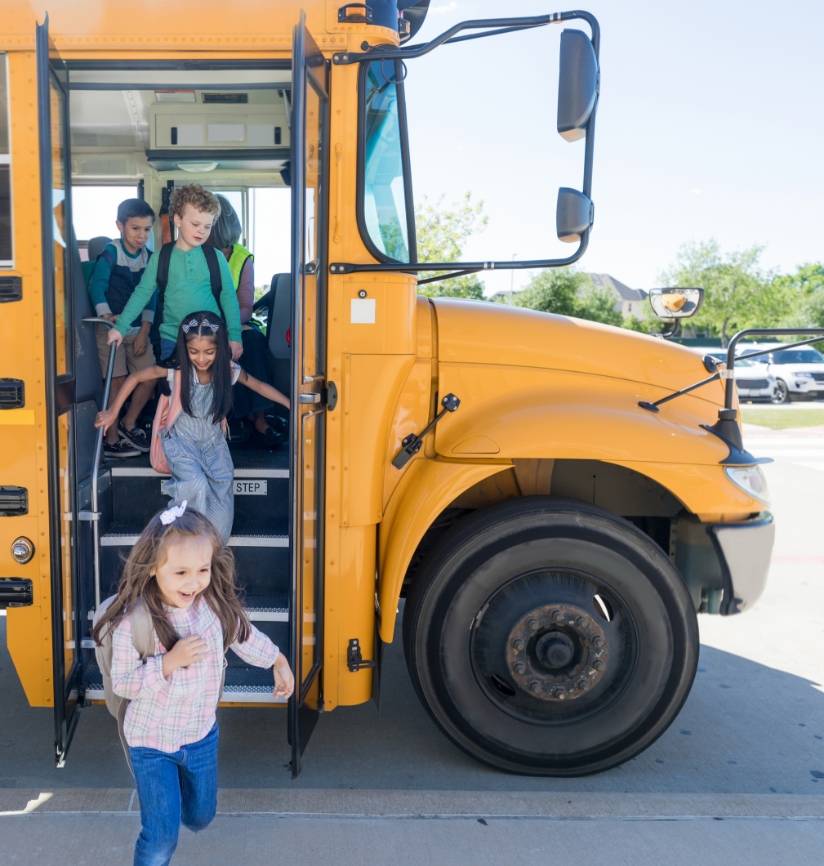 A yellow school bus dropping of kids